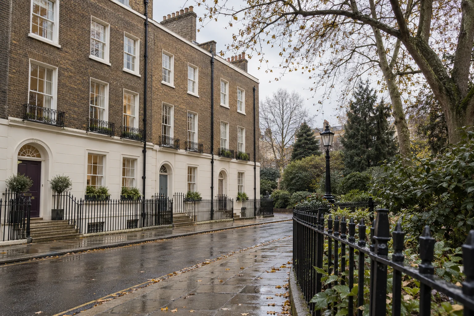 Brick Georgian terrace with sash windows and painted railings facing a formal garden